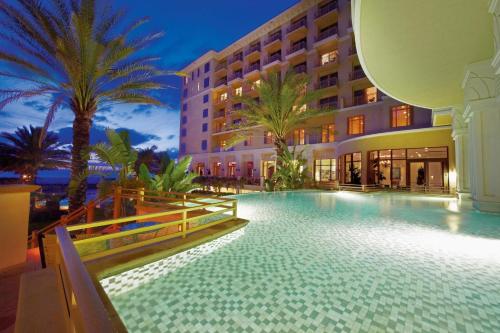 a swimming pool in front of a building with palm trees at Sandpearl Resort Private Beach in Clearwater Beach