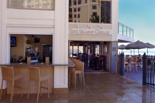 a restaurant with a bar with chairs and tables at Sandpearl Resort Private Beach in Clearwater Beach