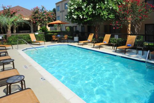 a large swimming pool with chairs and a table at Courtyard by Marriott Houston Hobby Airport in Houston