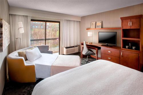 a hotel room with two beds and a television at Courtyard Parsippany in Parsippany