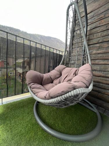 einen Hängesessel auf einem Balkon mit Gras in der Unterkunft Entire Private House in Roveredo