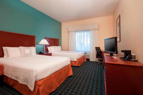 a hotel room with two beds and a flat screen tv at Fairfield Inn & Suites El Centro in El Centro