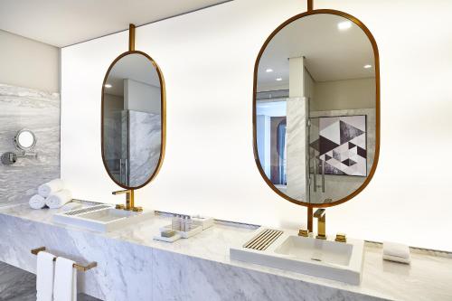 a bathroom with two mirrors on a counter at Sheraton Santos Hotel in Santos