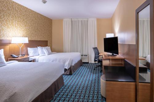 Habitación de hotel con 2 camas y escritorio con TV. en Fairfield Inn & Suites by Marriott Terrell, en Terrell