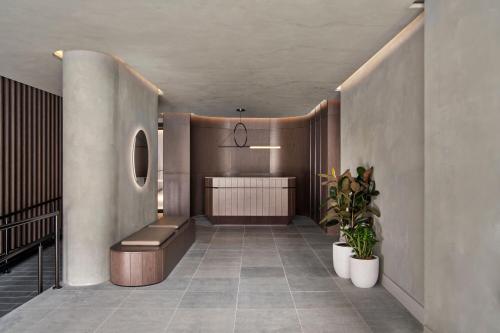 a hallway with a bench and a table and a plant at AC Hotel by Marriott Melbourne Southbank in Melbourne