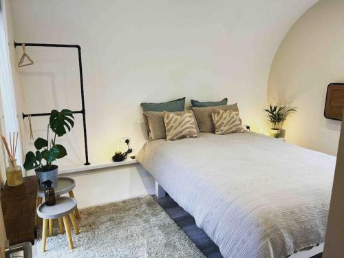 Un dormitorio con una gran cama blanca y una planta en The Grimsay Cabin en Carinish