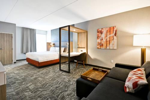 ブルー・アッシュにあるSpringHill Suites by Marriott Cincinnati Blue Ashのベッドとソファ付きのホテルルーム