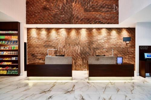 a lobby with two reception desks and a brick wall at Residence Inn by Marriott Rio de Janeiro Barra da Tijuca in Rio de Janeiro