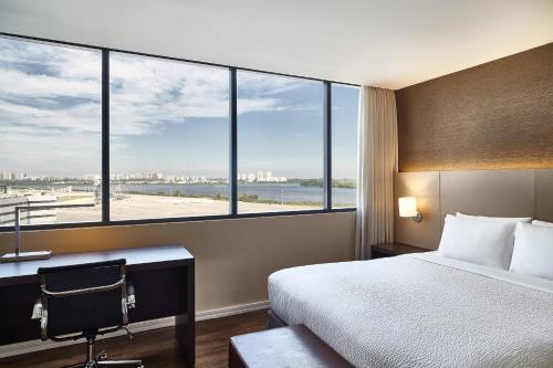 um quarto de hotel com uma cama, uma secretária e janelas em Residence Inn by Marriott Rio de Janeiro Barra da Tijuca no Rio de Janeiro