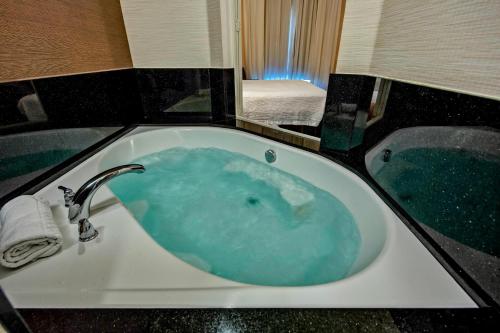 e bagno con vasca riempita di acqua blu. di Fairfield Inn and Suites by Marriott Weatherford a Weatherford