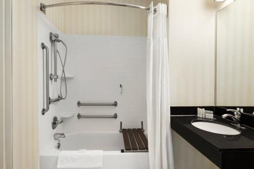 a bathroom with a tub and a sink and a shower at Fairfield Inn & Suites Stillwater in Stillwater