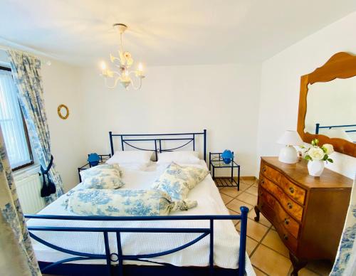 ein Schlafzimmer mit einem Bett, einer Kommode und einem Spiegel in der Unterkunft Barbarahof Ferienwohnung Vita Erdgeschoss in Markdorf