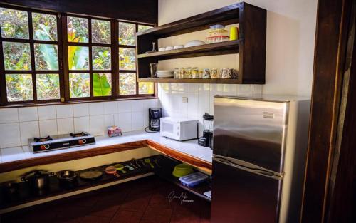 a kitchen with a refrigerator and a microwave at FLOR DE PARAISO BUNGALOWS in Montezuma