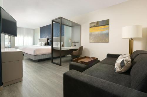 een hotelkamer met een bank en een bed bij SpringHill Suites by Marriott Lindale in Lindale