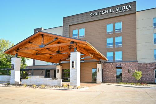 a building with a large wooden structure in front of it at SpringHill Suites by Marriott Lindale Tyler in Lindale