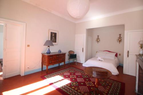 a bedroom with a bed and a wooden table at Roussy Nîmes Romaine in Nîmes