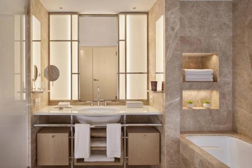 a bathroom with a sink and a tub at The Ritz-Carlton, Wolfsburg in Wolfsburg