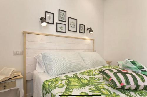 a bedroom with a bed with a wooden headboard at Catalogna10 Rooms in Alghero
