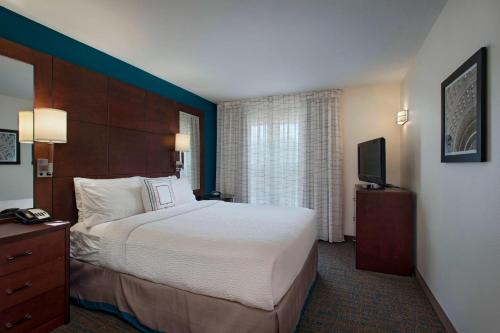 a hotel room with a large bed and a television at Residence Inn Bryan College Station in College Station