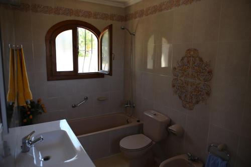 a bathroom with a sink and a toilet and a tub at Superb villa with heated private pool - stunning sea and mountain views- Air con in Teulada