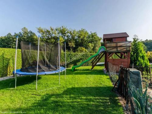 a playground with a slide and a play structure at Domki na Chabrowej in Augustów