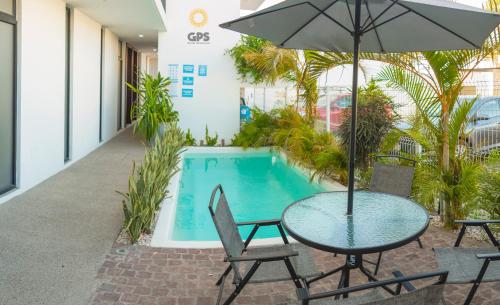 a table with an umbrella next to a swimming pool at Hotel boutique 402 in Mazatlán