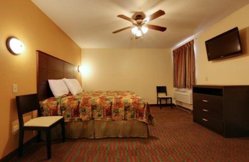 a hotel room with a bed and a ceiling fan at Guest Inn San Benito/Harlingen in San Benito