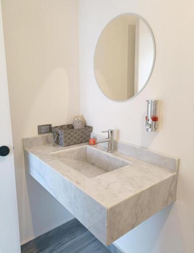 a bathroom with a stone sink and a mirror at Excelente Depa en Sabalo Country in Mazatlán