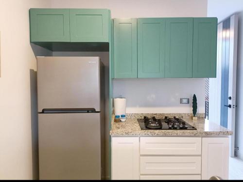 uma cozinha com armários verdes e um frigorífico em Excelente Depa en Sabalo Country em Mazatlán