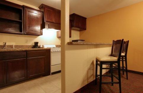 a kitchen with two chairs and a table in it at Guest Inn San Benito/Harlingen in San Benito