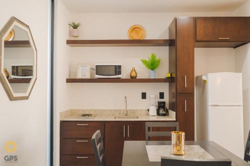 a kitchen with a sink and a refrigerator at Hotel boutique 402 in Mazatlán