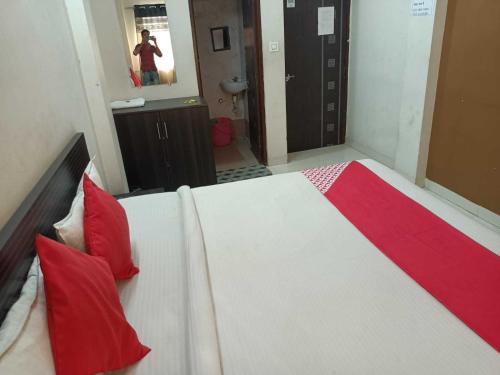 um quarto com uma cama grande e almofadas vermelhas em Flagship Om Gulmohar Avenue em Bhopal