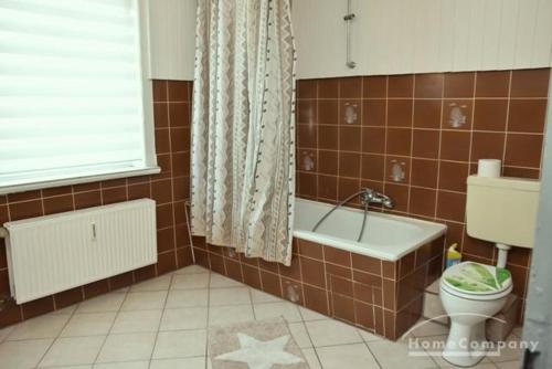 La salle de bains est pourvue de toilettes et d'une baignoire. dans l'établissement GARNI, à Hemmingen