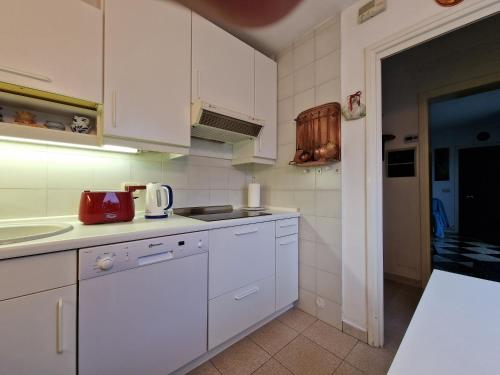 a kitchen with white cabinets and a red appliance at Casa Melina 2 in Tremezzo