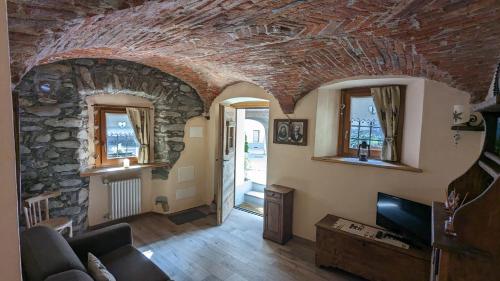 a living room with a stone wall at Maison du Pont Romain - CIR 0055 in Aosta