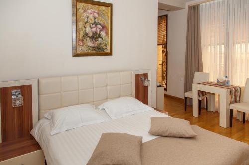 a bedroom with a large white bed and a table at Daniel Boutique Hotel in Yerevan