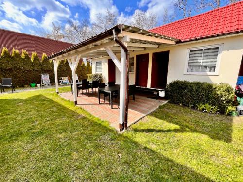 a pergola on a deck in the backyard of a house at Pokoje Nad Klifem in Trzęsacz