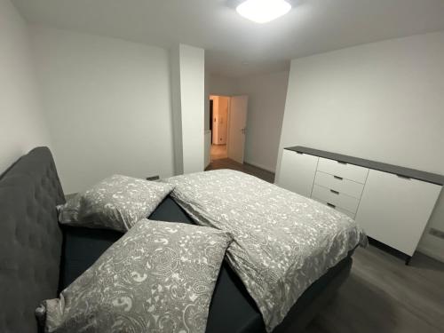 a bedroom with two beds and a dresser in it at Deluxe Appartement in Graben-Neudorf
