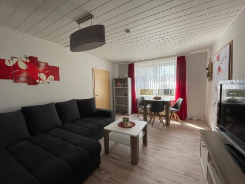 a living room with a black couch and a table at Ferienwohnung Levin in Dargun