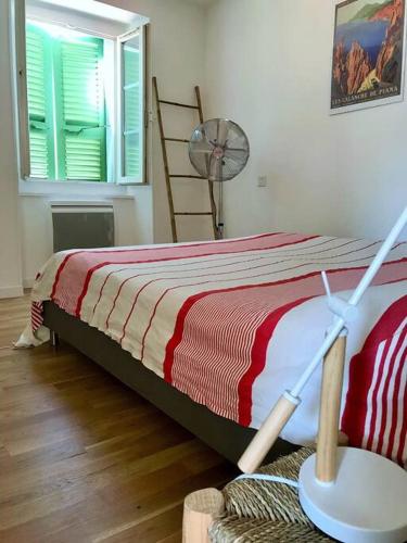- une chambre dotée d'un lit avec une couverture rouge et blanche dans l'établissement Charmant T3 Centre ville Corté, à Corte
