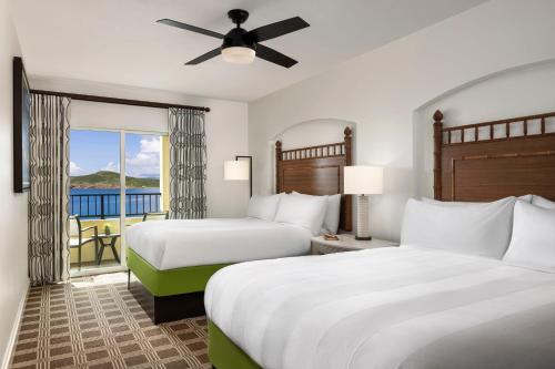 a hotel room with two beds and a balcony at Marriott's Frenchman's Cove in Estate Thomas