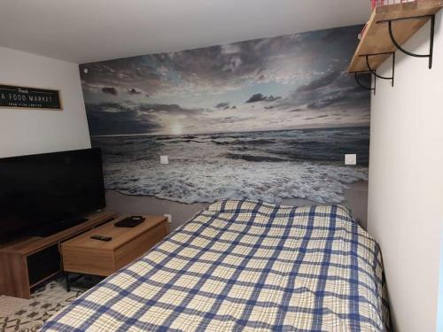 a bedroom with a bed and a painting of the ocean at Le Cantou de Juliette (studio) in Prugnanes