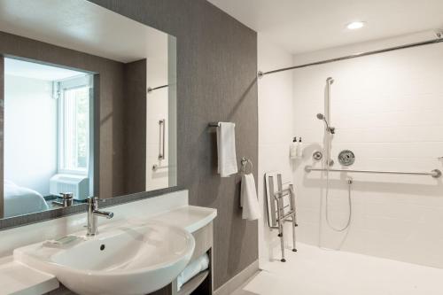 a white bathroom with a sink and a shower at SpringHill Suites by Marriott Chester in Chester