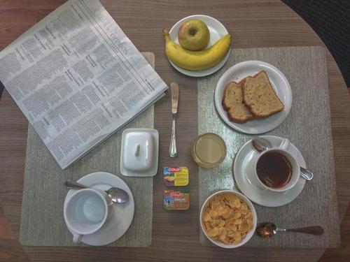 a table with plates of food and a cup of coffee at Chilhotel en Providencia in Santiago