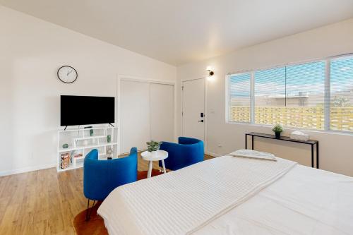um quarto com uma cama e duas cadeiras azuis em Cherry Avenue Studio em Tucson