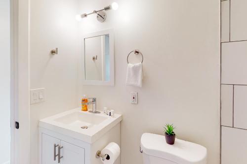 uma casa de banho branca com um lavatório e um WC em Cherry Avenue Studio em Tucson