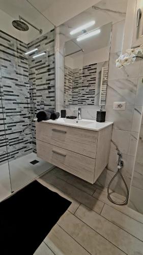 a bathroom with a sink and a large mirror at Casa Melina 1 in Tremezzo
