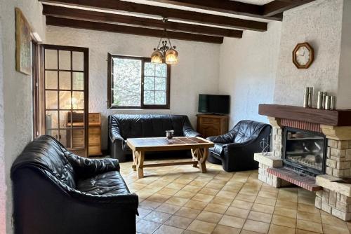 ein Wohnzimmer mit Ledermöbeln und einem Kamin in der Unterkunft Maison de vacances Diff in Puttelange-aux-Lacs
