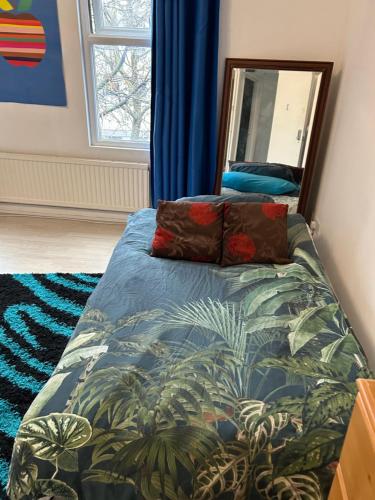 1 dormitorio con cama y espejo en Cozy 4 Bed Flat in Islington London, en Londres