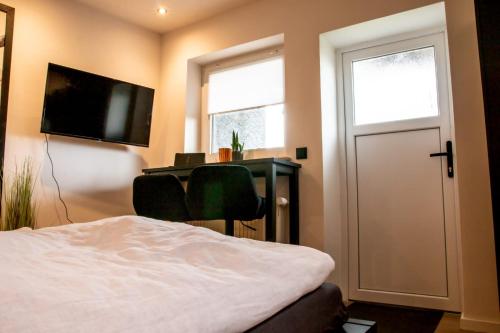 a bedroom with a bed and a desk and a television at Studio 20for2 Nähe Köln in Bergisch Gladbach